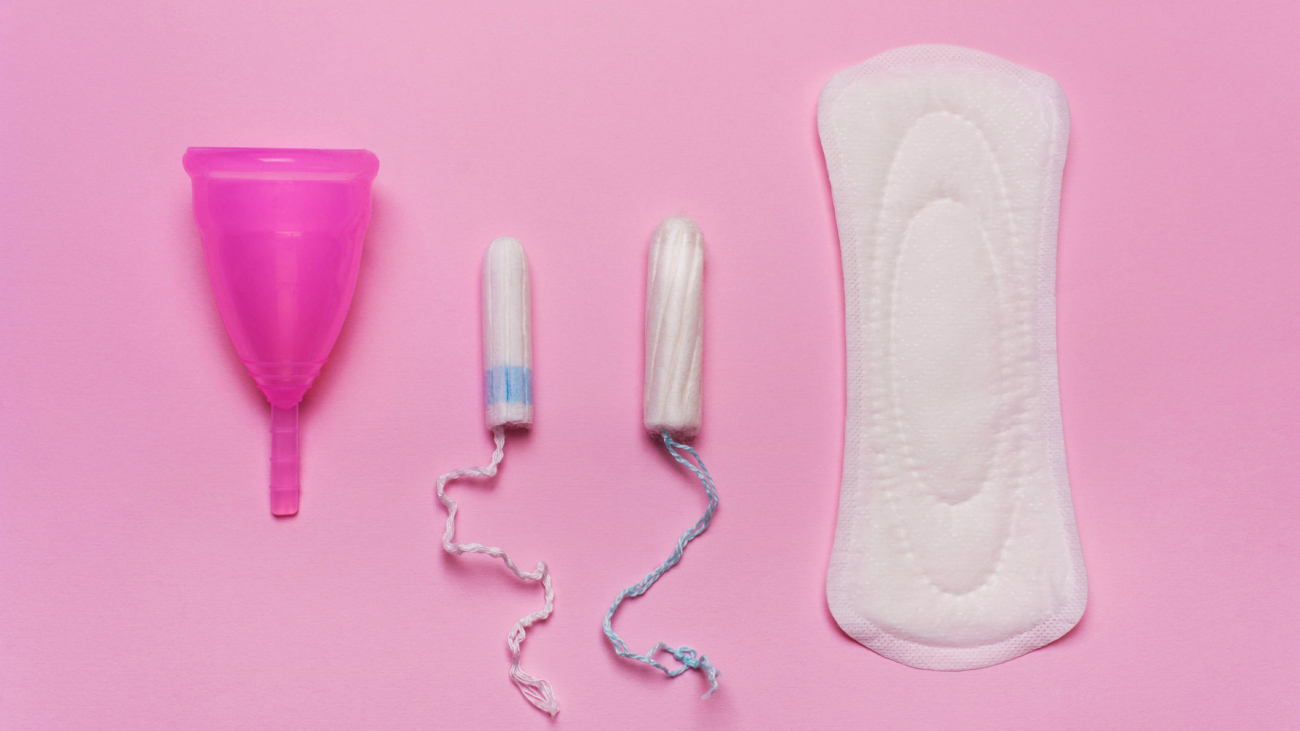 Pad, menstrual cup, tampon on a pink background. The view is flat. Concept of critical days, menstruation